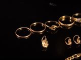many different types of gold rings on a black surface
