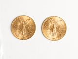 two gold coins sitting next to each other on a white surface