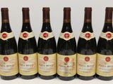 six bottles of red wine are lined up on a table