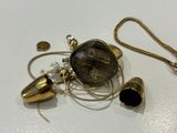 a gold necklace with a black stone on it