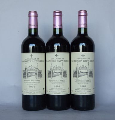 trois bouteilles de vin rouge posées sur une table l'une à côté de l'autre