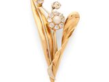 a close up of a flower brooch with a pearl center