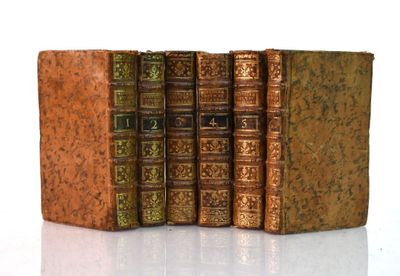 plusieurs vieux livres sont empilés sur une surface blanche