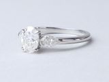 une image d'une bague en diamant sur une surface blanche
