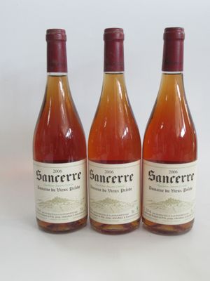trois bouteilles de vin posées les unes à côté des autres sur une surface blanche