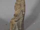 a small stone sculpture of a man on a white surface