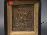 une vieille plaque métallique sur laquelle figure l'image d'un homme à cheval