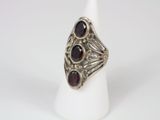 a close up of a silver ring with garnets on it