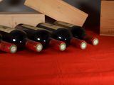 several bottles of wine are lined up on a red table cloth