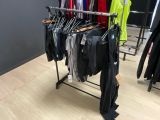 un portemanteau dans un magasin de vêtements, sur lequel sont suspendus des vêtements