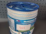 un récipient en plastique avec un couvercle bleu, posé sur une étagère dans un magasin
