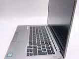 a silver laptop computer sitting on top of a white table