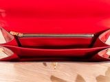 the inside of a red purse on a wooden table