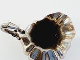 a silver cup that is sitting on a white surface