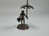 a bronze statue of a man holding an umbrella