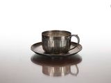 une tasse et une soucoupe en argent posées sur une table