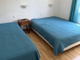 two beds in the room with blue sheets on them