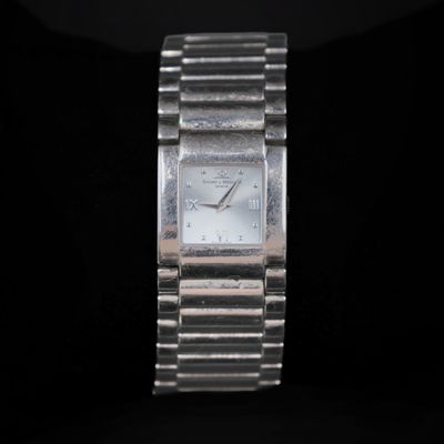 a close up of a silver watch on a black background