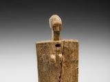 une figurine en bois représentant un homme tenant un bouclier