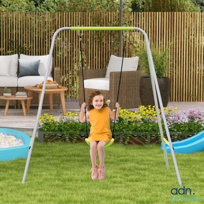 a young girl swinging on a swing set in the yard