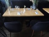 a wooden table with four chairs and a vase with flowers on it