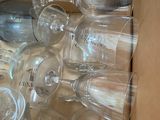 a box full of empty wine glasses sitting on the floor