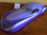 une petite voiture violette posée sur une table en bois