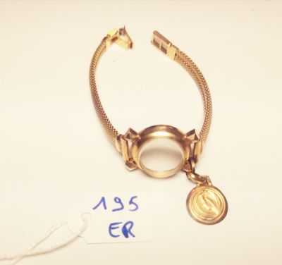 gold plated bracelet with a coin and a tag on a white surface