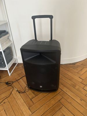 a black speaker that is sitting on a hard wood floor