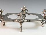 a silver plate with two figurines on top of it