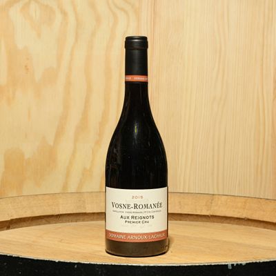 a bottle of wine sitting on top of a barrel