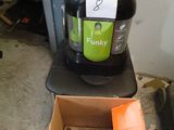 un aspirateur vert et noir posé sur une boîte en carton