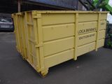 a yellow dumpster that is sitting in the parking lot