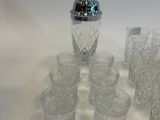 many glasses and a shaker sitting on a table