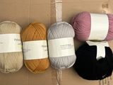 trois pelotes de laine posées sur une boîte en carton