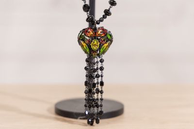 collier de perles noires avec une perle en verre multicolore et un pompon