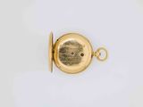 a gold pocket watch on a white surface