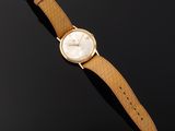 a gold wrist watch with a white dial and brown leather strap
