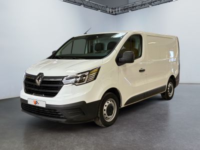 La camionnette blanche est garée dans une grande pièce.