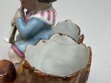 a ceramic figurine of a little girl sitting on a flower pot