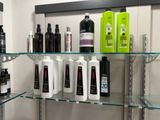 many bottles of hair products on the shelves in the bathroom