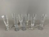 six verres à vin transparents alignés en rang sur une table