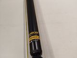 a close up of a black and yellow stick on a white surface