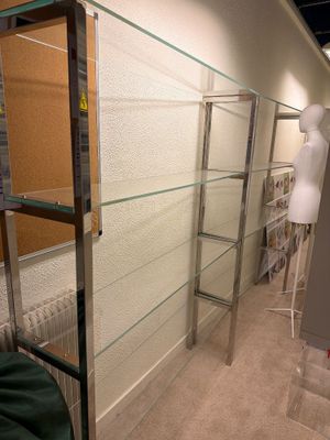 une vitrine avec des étagères en verre dans une pièce