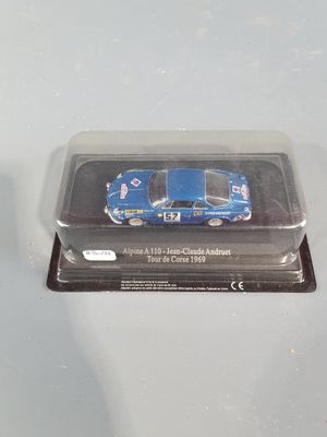 a small blue car in a plastic container on a table