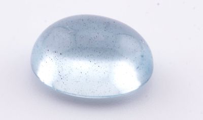 un gros plan d'un objet en verre bleu posé sur une surface blanche