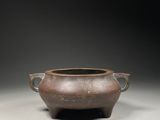 an old brown pot sitting on top of a table next to another pot