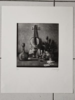 photographie en noir et blanc représentant une nature morte avec un violon et d'autres objets