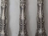 four silverware pieces are lined up in a row on a table