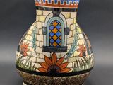 a vase with a colorful design on it on a gray surface